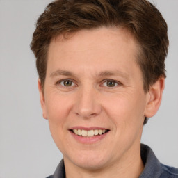 Joyful white adult male with short  brown hair and grey eyes