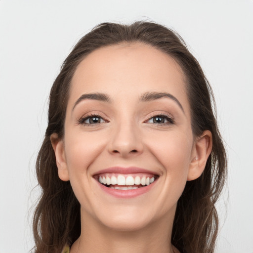 Joyful white young-adult female with long  brown hair and grey eyes