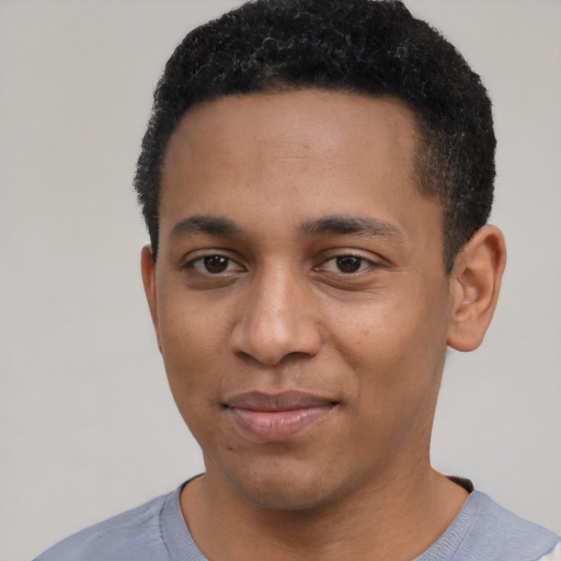 Joyful black young-adult male with short  black hair and brown eyes