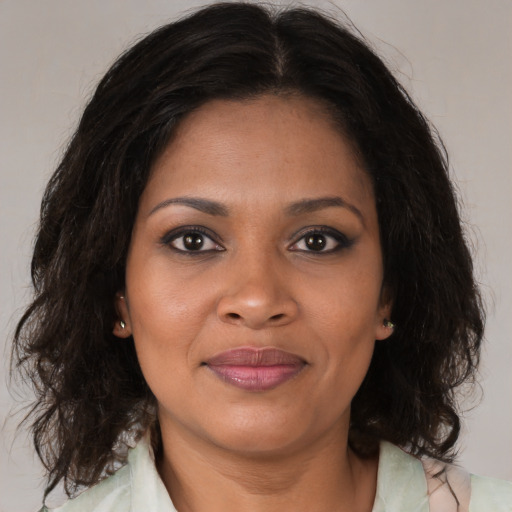 Joyful black adult female with medium  brown hair and brown eyes