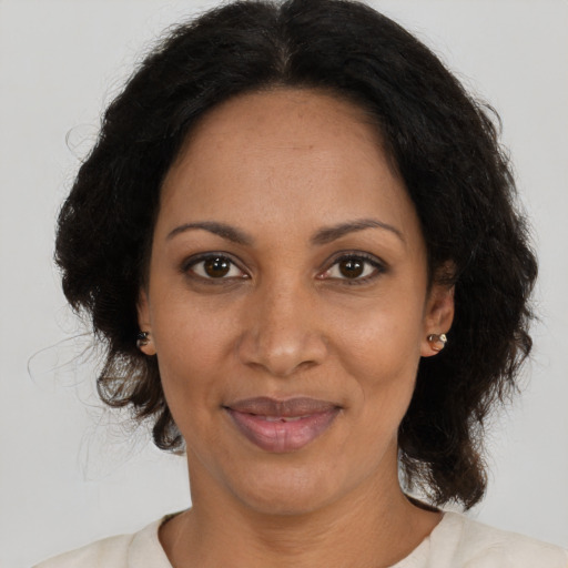 Joyful black adult female with medium  brown hair and brown eyes