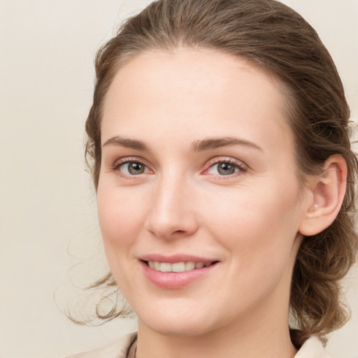 Joyful white young-adult female with medium  brown hair and green eyes