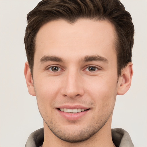 Joyful white young-adult male with short  brown hair and brown eyes