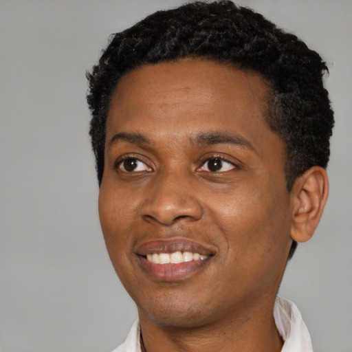Joyful black young-adult male with short  black hair and brown eyes
