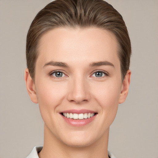 Joyful white young-adult female with short  brown hair and grey eyes