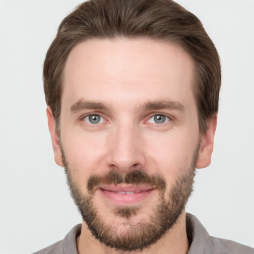 Joyful white young-adult male with short  brown hair and grey eyes