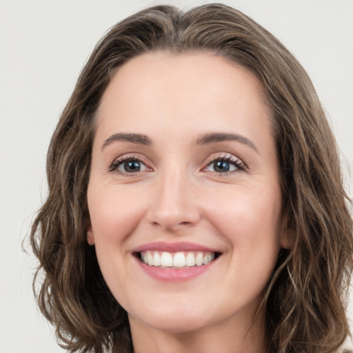 Joyful white young-adult female with long  brown hair and green eyes