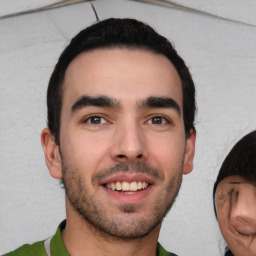 Joyful white young-adult male with short  black hair and brown eyes