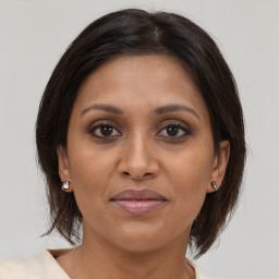 Joyful black adult female with medium  brown hair and brown eyes