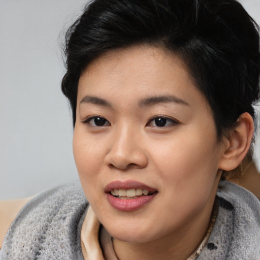 Joyful asian young-adult female with short  black hair and brown eyes