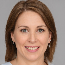 Joyful white adult female with medium  brown hair and grey eyes