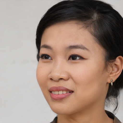 Joyful asian young-adult female with medium  brown hair and brown eyes