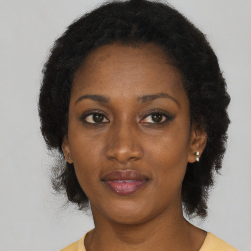 Joyful black adult female with medium  brown hair and brown eyes
