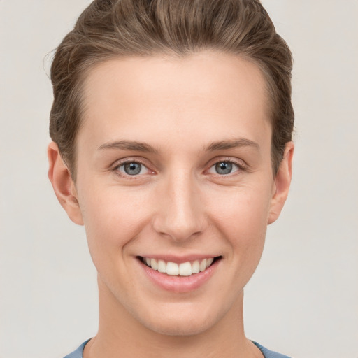 Joyful white young-adult female with short  brown hair and grey eyes