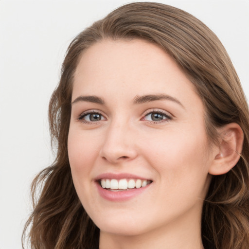 Joyful white young-adult female with long  brown hair and blue eyes