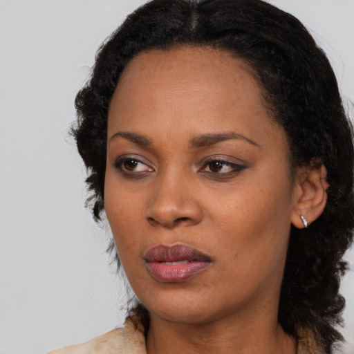 Joyful black young-adult female with long  black hair and brown eyes