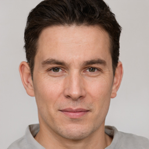 Joyful white adult male with short  brown hair and brown eyes