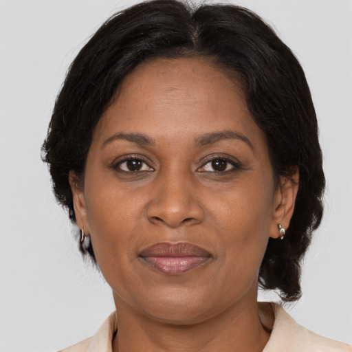 Joyful black adult female with medium  brown hair and brown eyes