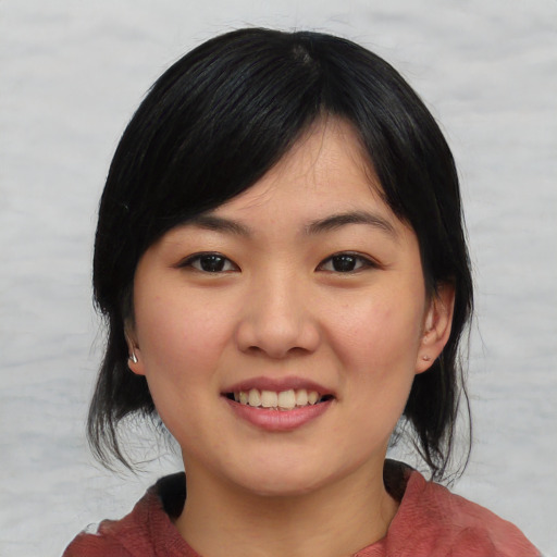 Joyful asian young-adult female with medium  black hair and brown eyes