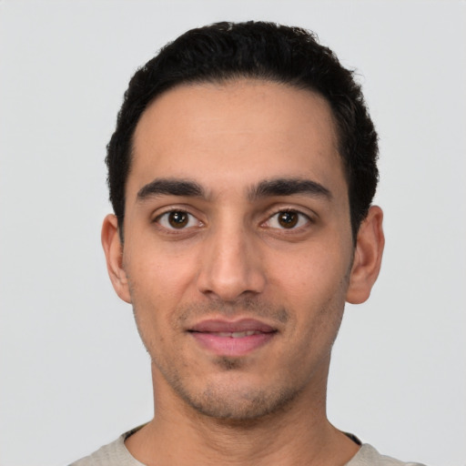 Joyful latino young-adult male with short  black hair and brown eyes