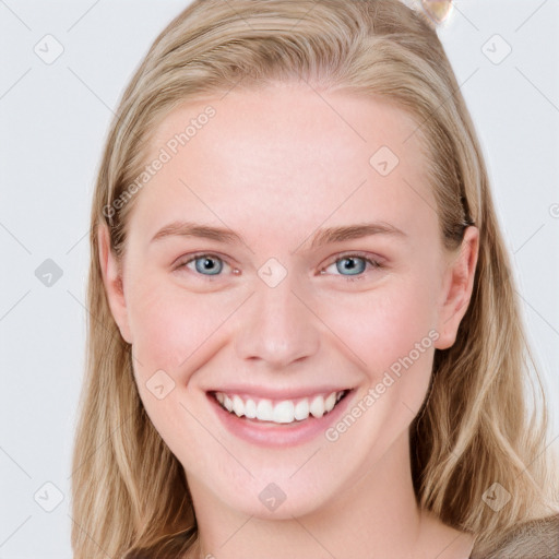 Joyful white young-adult female with long  brown hair and blue eyes