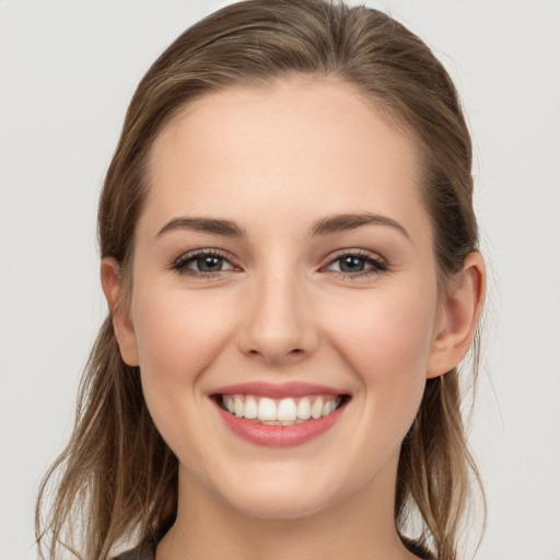 Joyful white young-adult female with long  brown hair and grey eyes