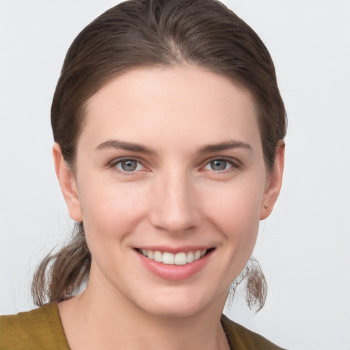 Joyful white young-adult female with medium  brown hair and grey eyes