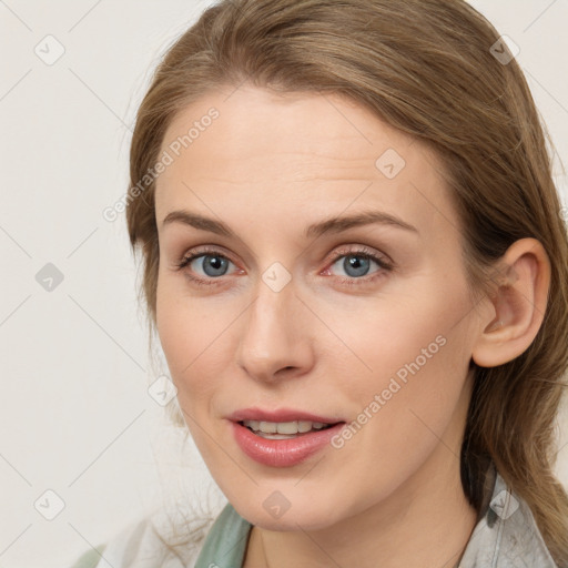 Joyful white young-adult female with medium  brown hair and blue eyes