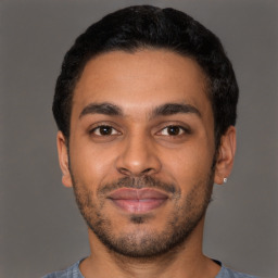 Joyful latino young-adult male with short  brown hair and brown eyes