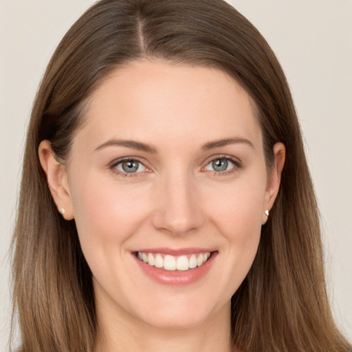 Joyful white young-adult female with long  brown hair and grey eyes