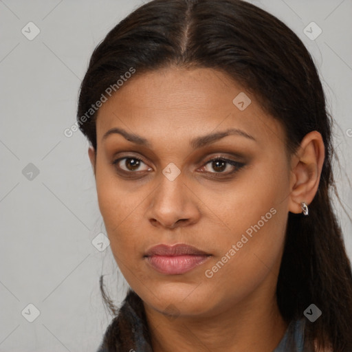 Joyful black young-adult female with long  brown hair and brown eyes