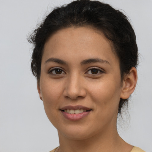 Joyful latino young-adult female with short  brown hair and brown eyes