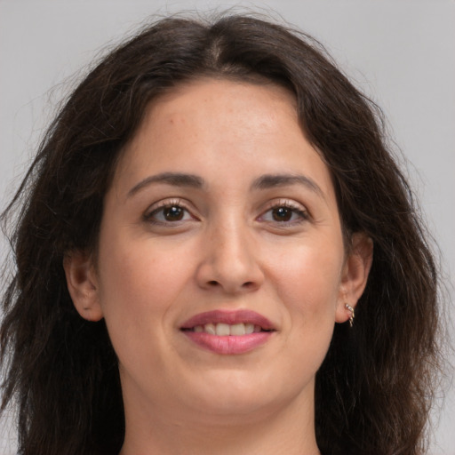 Joyful white young-adult female with long  brown hair and brown eyes