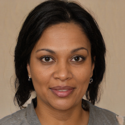 Joyful black adult female with medium  brown hair and brown eyes