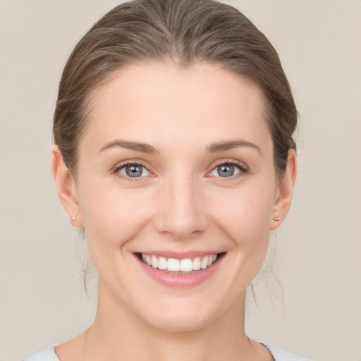 Joyful white young-adult female with medium  brown hair and grey eyes