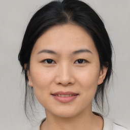 Joyful asian young-adult female with medium  black hair and brown eyes