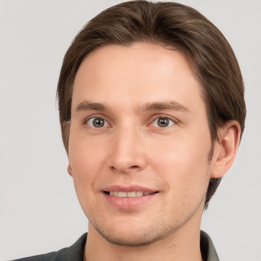 Joyful white young-adult male with short  brown hair and grey eyes