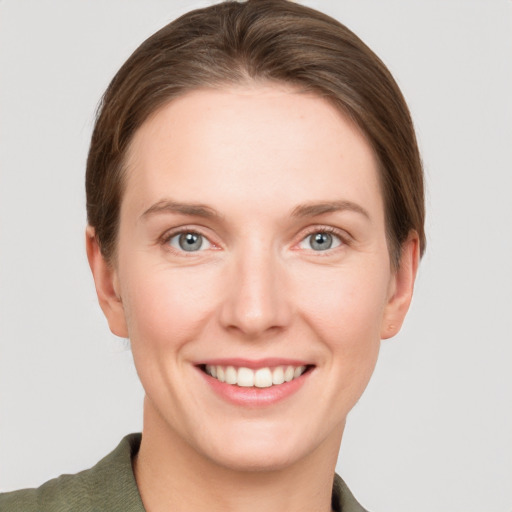 Joyful white young-adult female with short  brown hair and grey eyes