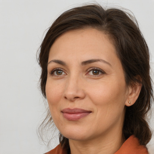 Joyful white adult female with medium  brown hair and brown eyes