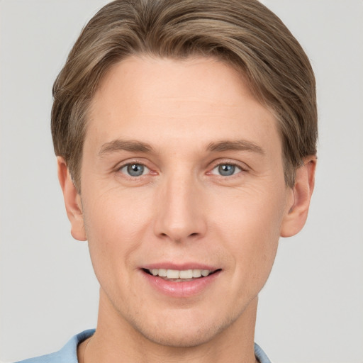 Joyful white young-adult male with short  brown hair and grey eyes