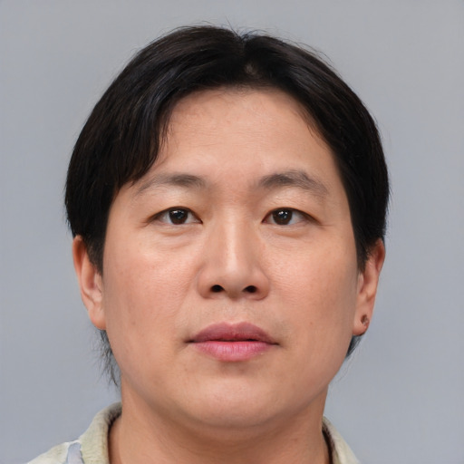 Joyful asian adult male with short  brown hair and brown eyes