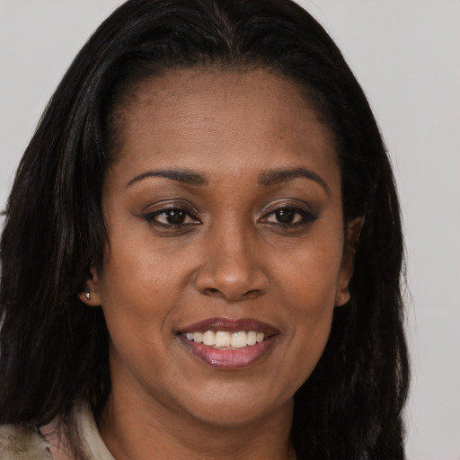 Joyful black young-adult female with long  brown hair and brown eyes