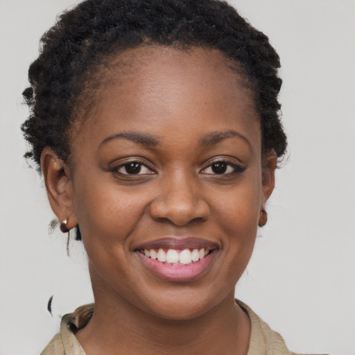 Joyful black young-adult female with short  brown hair and brown eyes