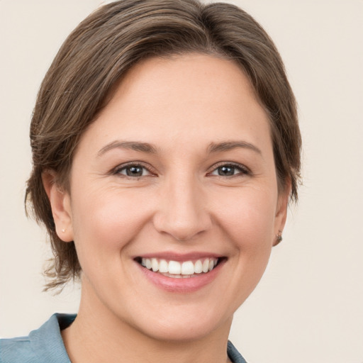 Joyful white young-adult female with medium  brown hair and grey eyes