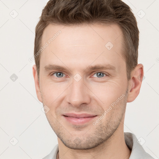 Joyful white young-adult male with short  brown hair and grey eyes