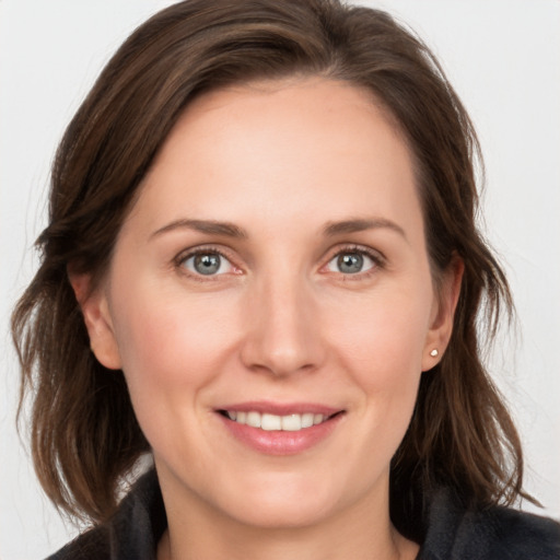 Joyful white young-adult female with medium  brown hair and grey eyes