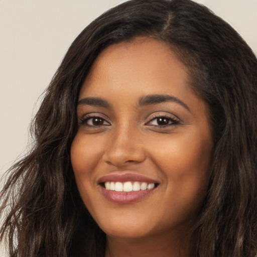 Joyful latino young-adult female with long  brown hair and brown eyes