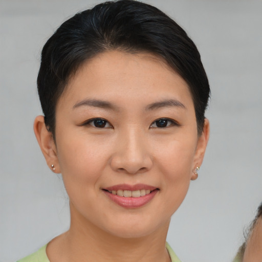Joyful asian young-adult female with short  brown hair and brown eyes