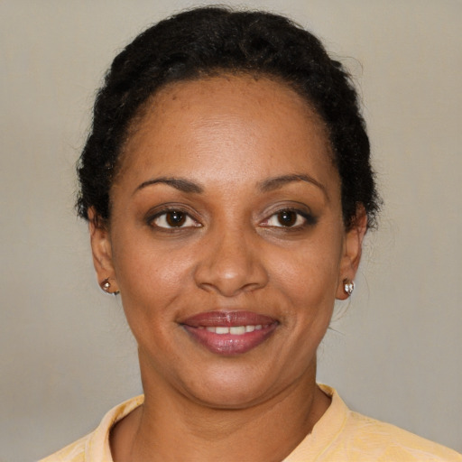 Joyful black young-adult female with short  brown hair and brown eyes