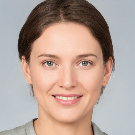 Joyful white young-adult female with medium  brown hair and grey eyes